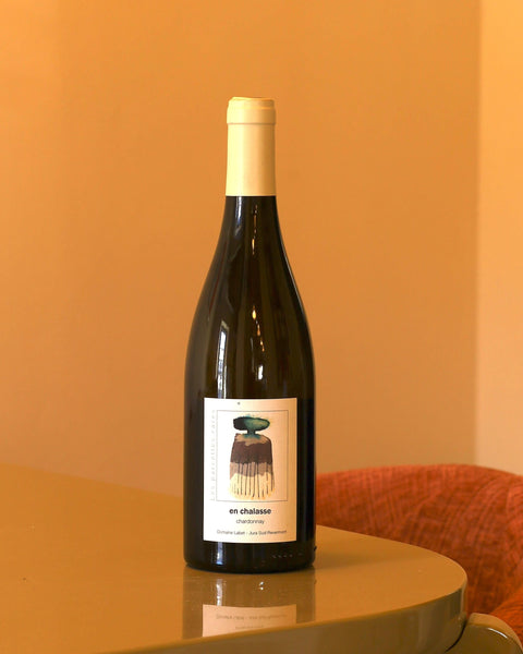 Bottiglia di vino bianco Domaine Labet Chardonnay En Chalasse 2020 da 0,75l con etichetta artistica su sfondo color pesca.