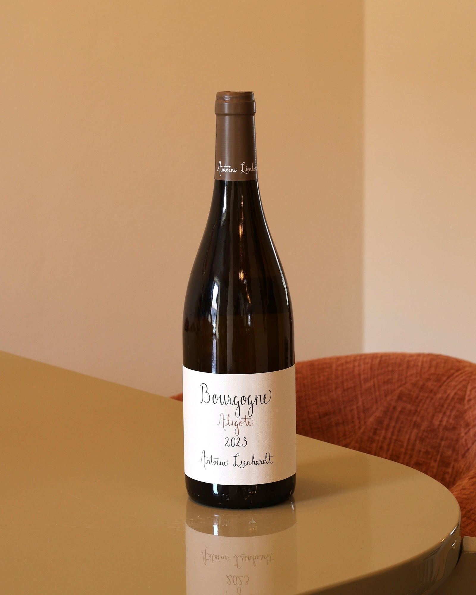Bottiglia di vino bianco Antoine Lienhardt Bourgogne Aligote 2023 da 0,75l con etichetta minimalista su tavolo lucido.