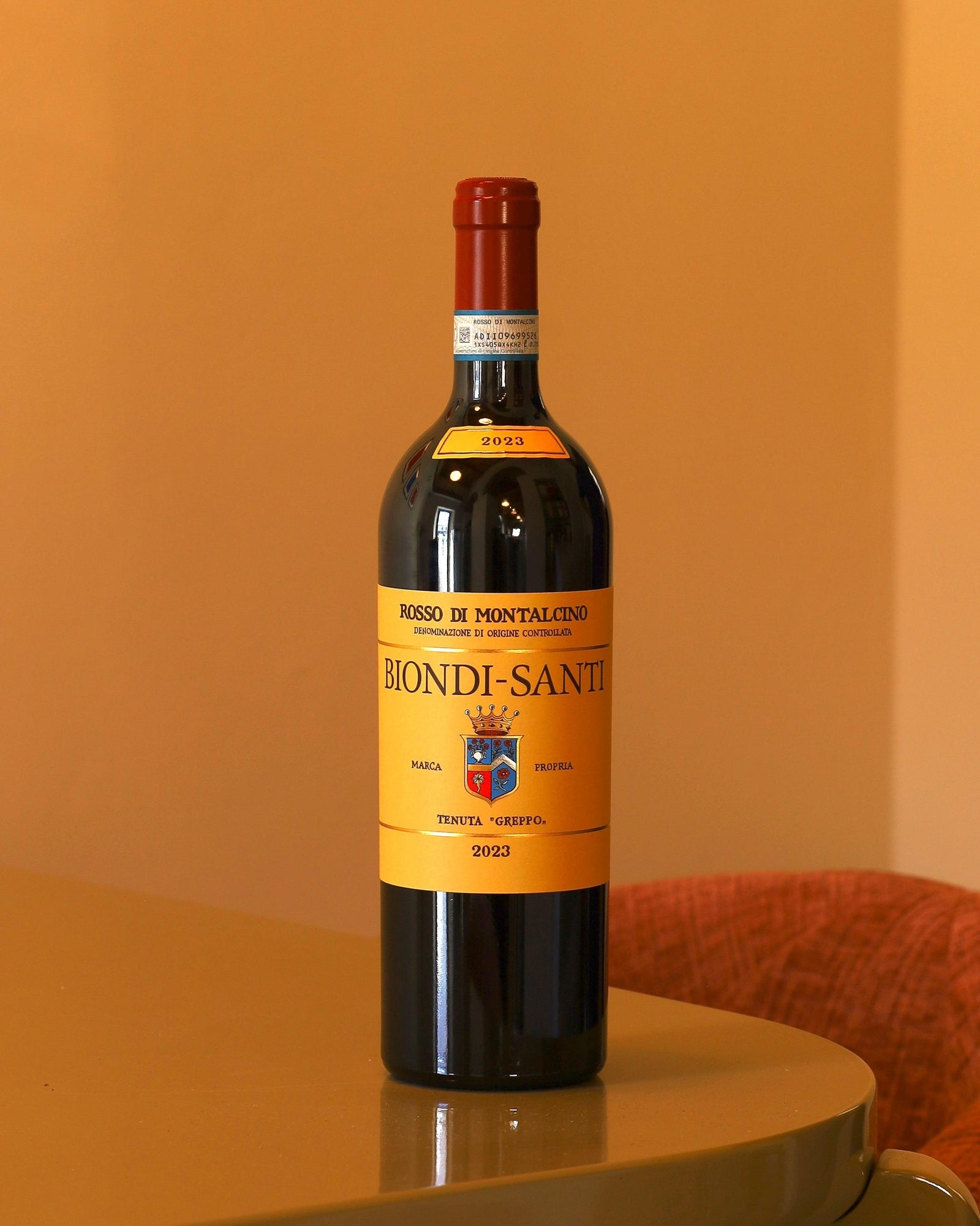 Bottiglia di vino rosso Biondi Santi Rosso di Montalcino 2023 da 0,75l con etichetta gialla classica su sfondo neutro.