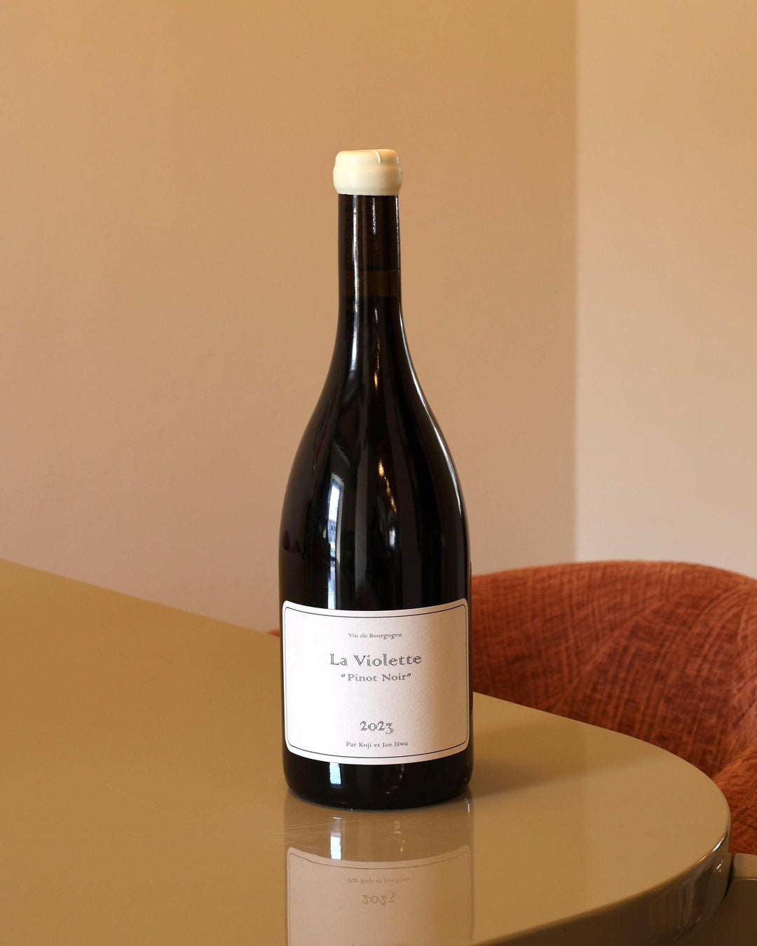 Bottiglia di Pinot Noir Domaine Koji et Jae Hwa La Violette 2023 con etichetta minimalista su tavolo lucido.
