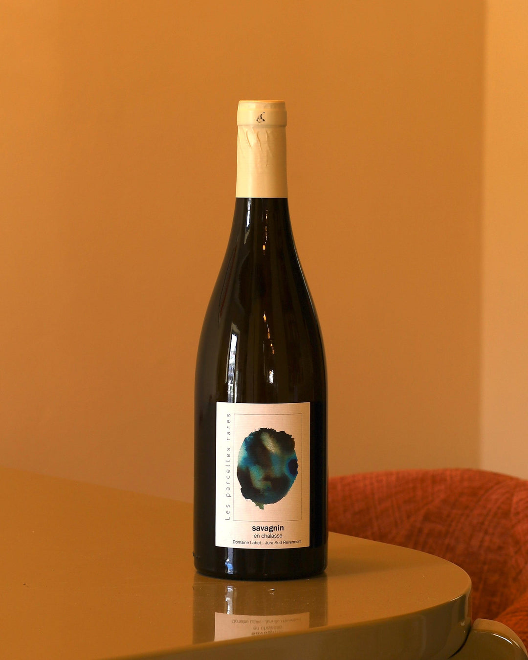 Bottiglia di vino bianco Domaine Labet Fleur de Savagnin En Chalasse 2023 con etichetta artistica su sfondo ambrato.