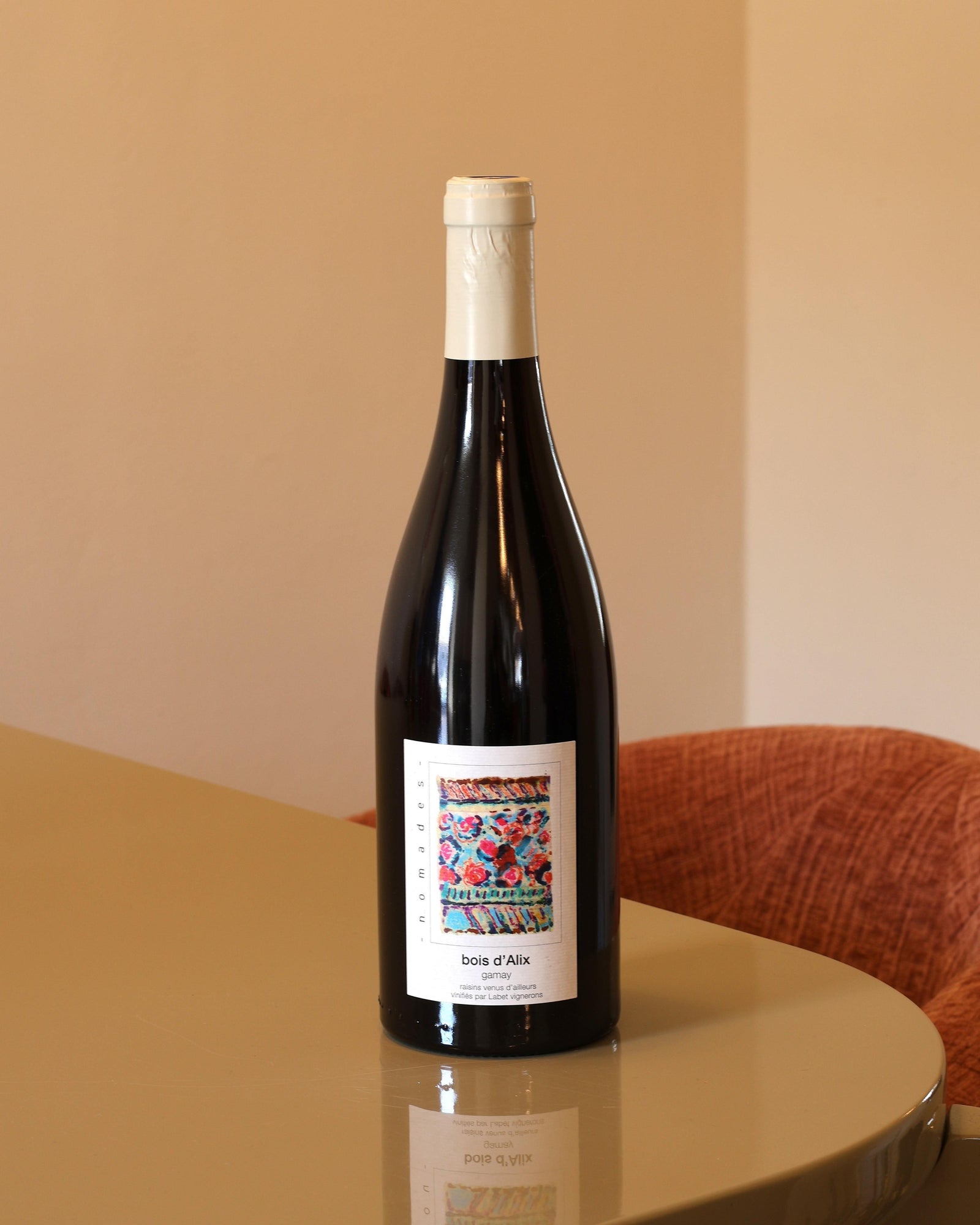 Bottiglia di vino rosso Domaine Labet Les Boix D'Alix Gamay 2024 con etichetta artistica colorata su tavolo lucido.