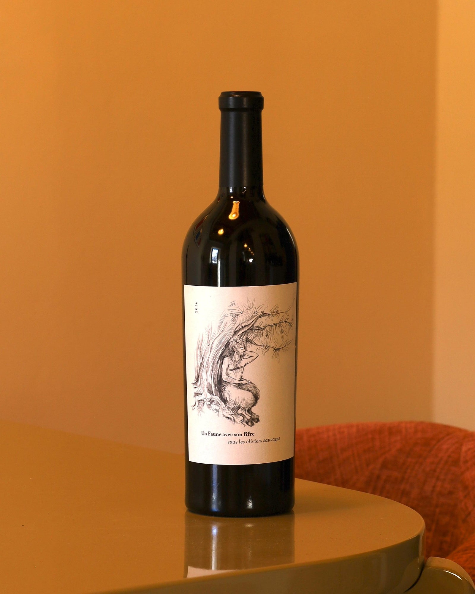 Bottiglia di vino rosso Domaine du Clos des Fees 2016 con etichetta illustrata su sfondo color ocra.