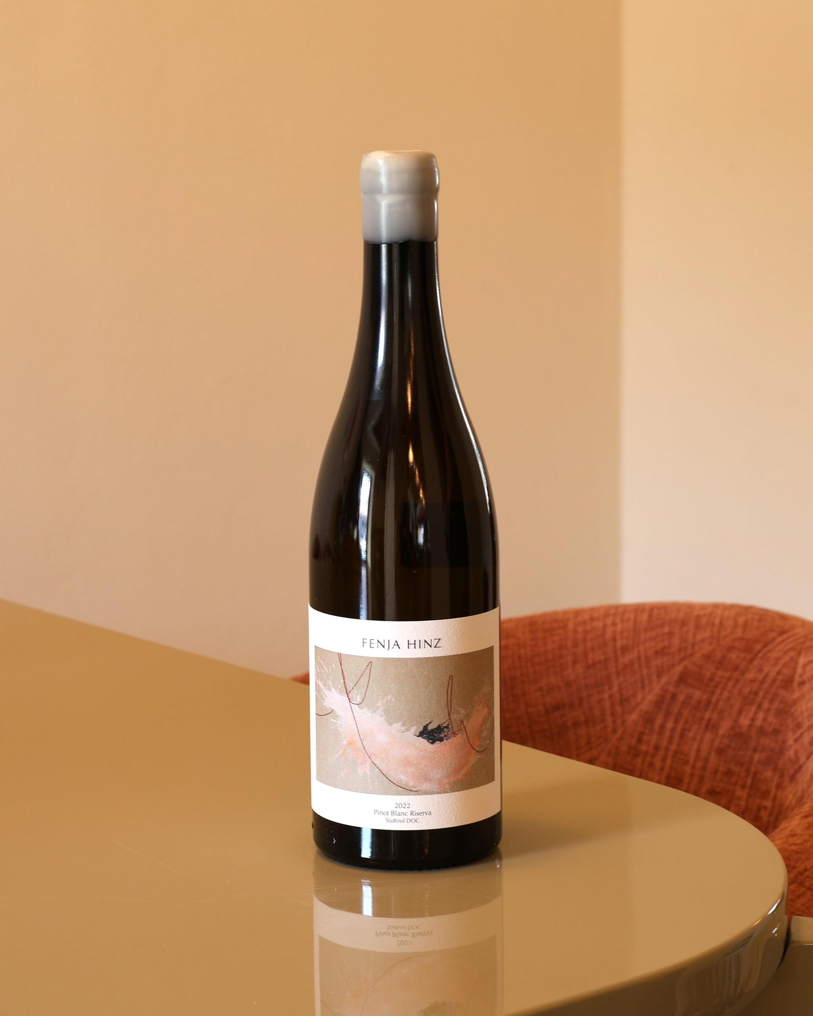 Bottiglia di Fenja Hinz Pinot Bianco Riserva 2022 da 0,75l con tappo in cera su tavolo lucido.
