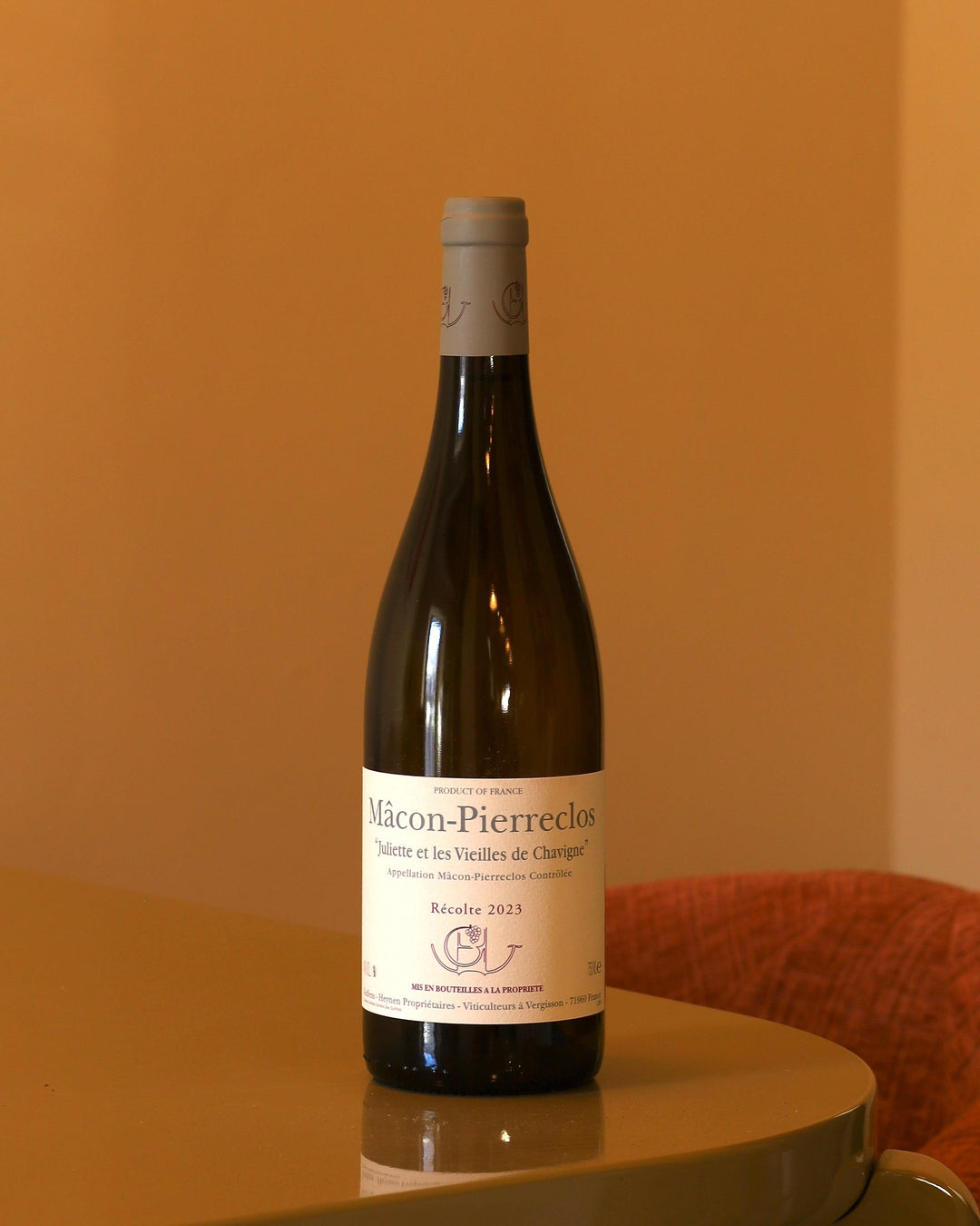 Bottiglia di vino bianco Guffens-Heynen Mâcon-Pierreclos 2023 con etichetta chiara su sfondo ambrato.