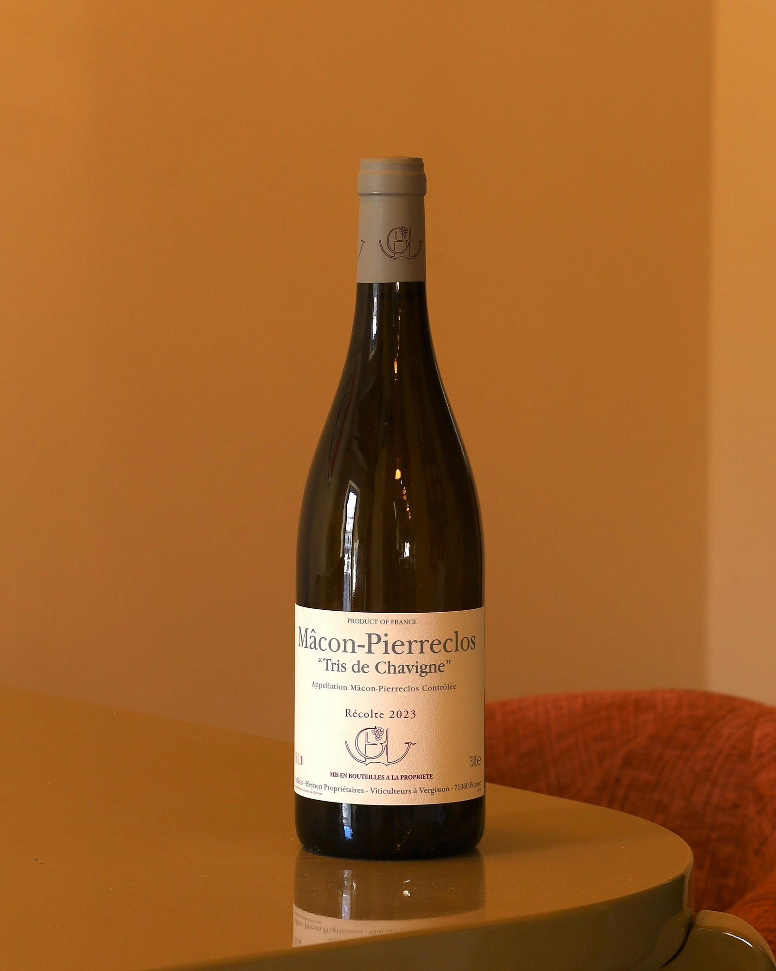 Bottiglia di vino bianco Guffens-Heynen Mâcon-Pierreclos 2023 con etichetta chiara su sfondo color ocra.