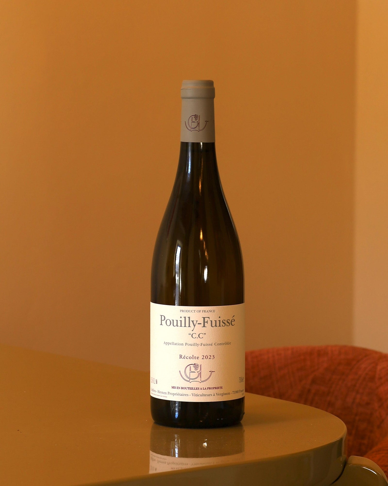 Bottiglia di vino bianco Guffens-Heynen Pouilly-Fuissé C.C. 2023 con etichetta chiara su tavolo lucido.