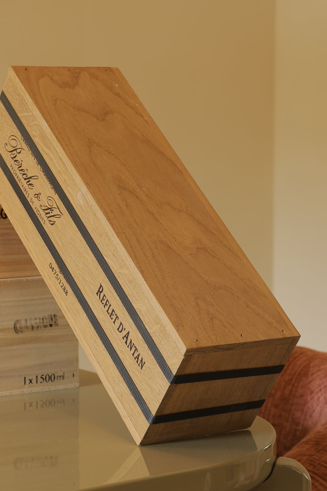 Wooden Bérèche et Fils champagne crate labeled Reflet d'Antan resting on a reflective surface.