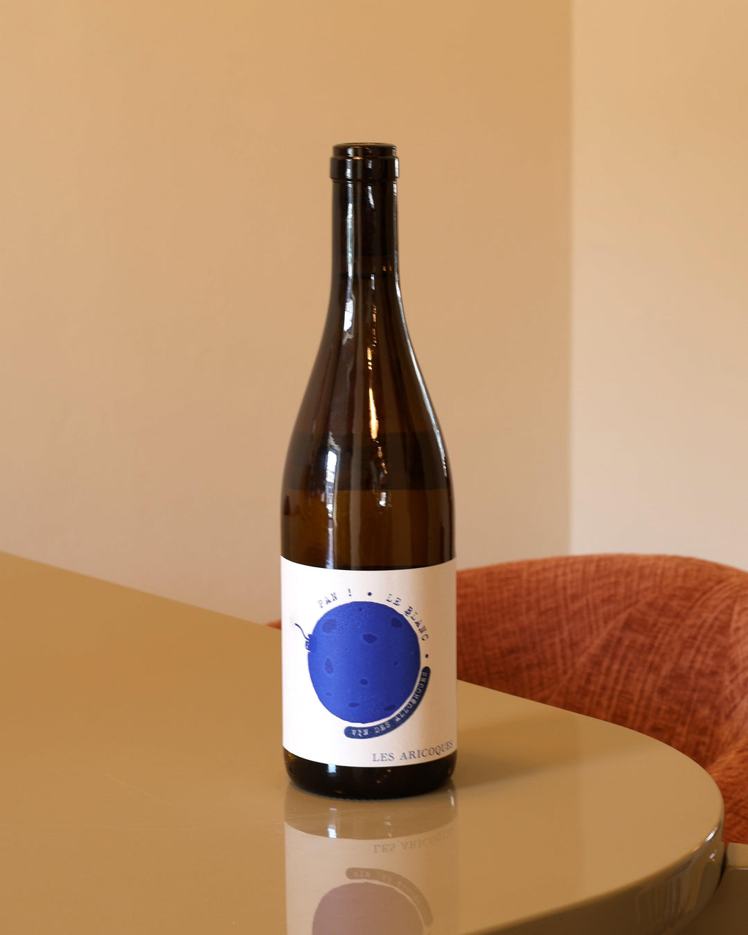 Bottiglia di vino bianco Les Aricoques Pan Bianco 0,75l con etichetta bianca e cerchio blu su tavolo lucido.