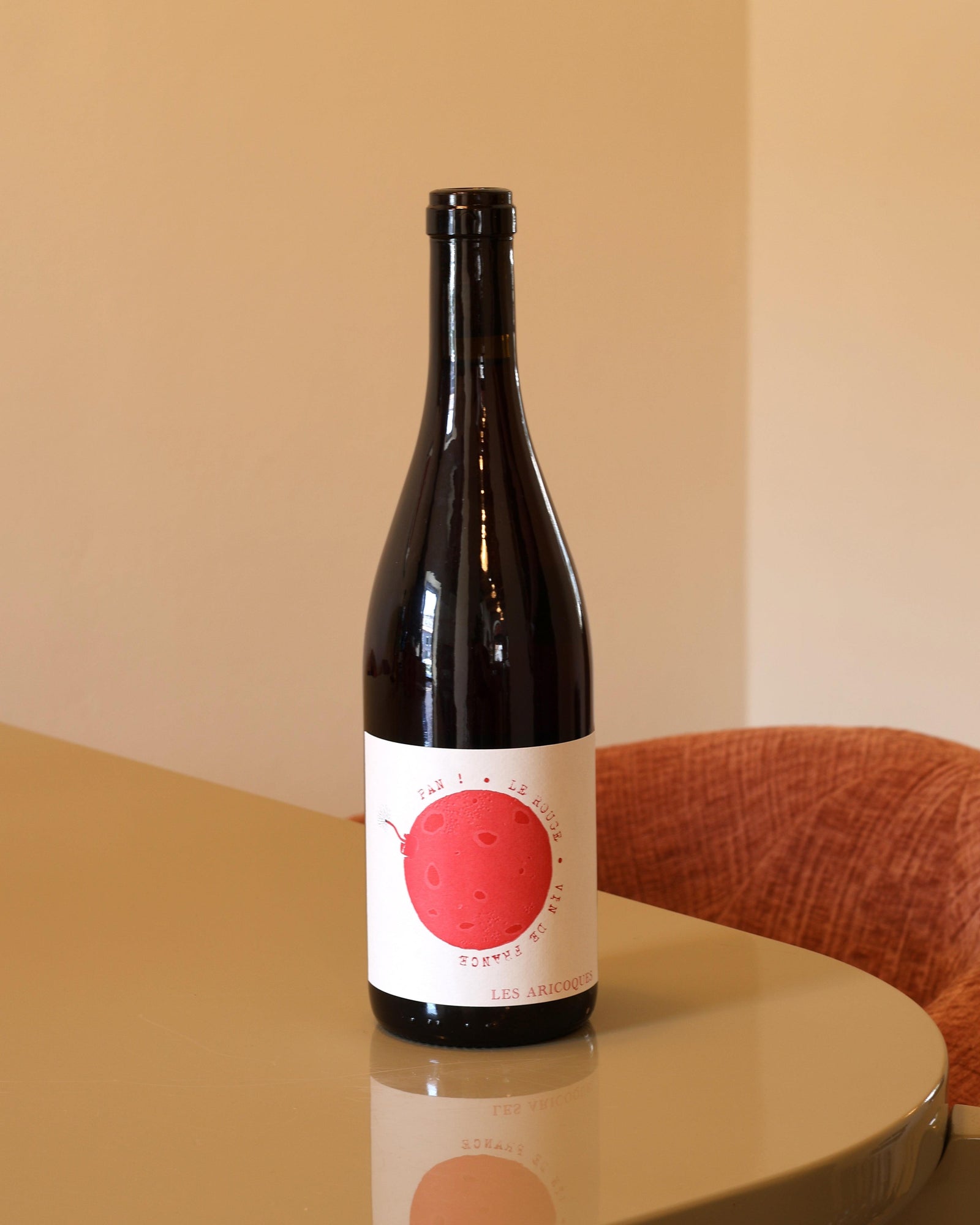 Bottiglia di vino rosso Les Aricoques Pan Rouge 2024 da 0,75l con etichetta bianca e grafica circolare rossa.