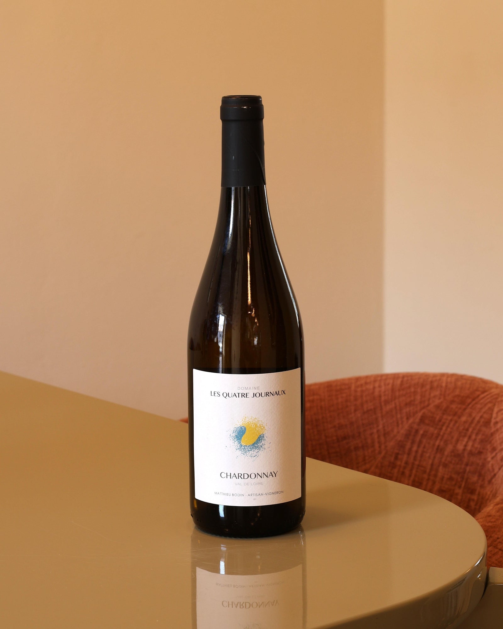 Bottiglia di vino bianco Les Quatre Journaux Chardonnay 2024 da 0,75l con etichetta minimalista su tavolo lucido.