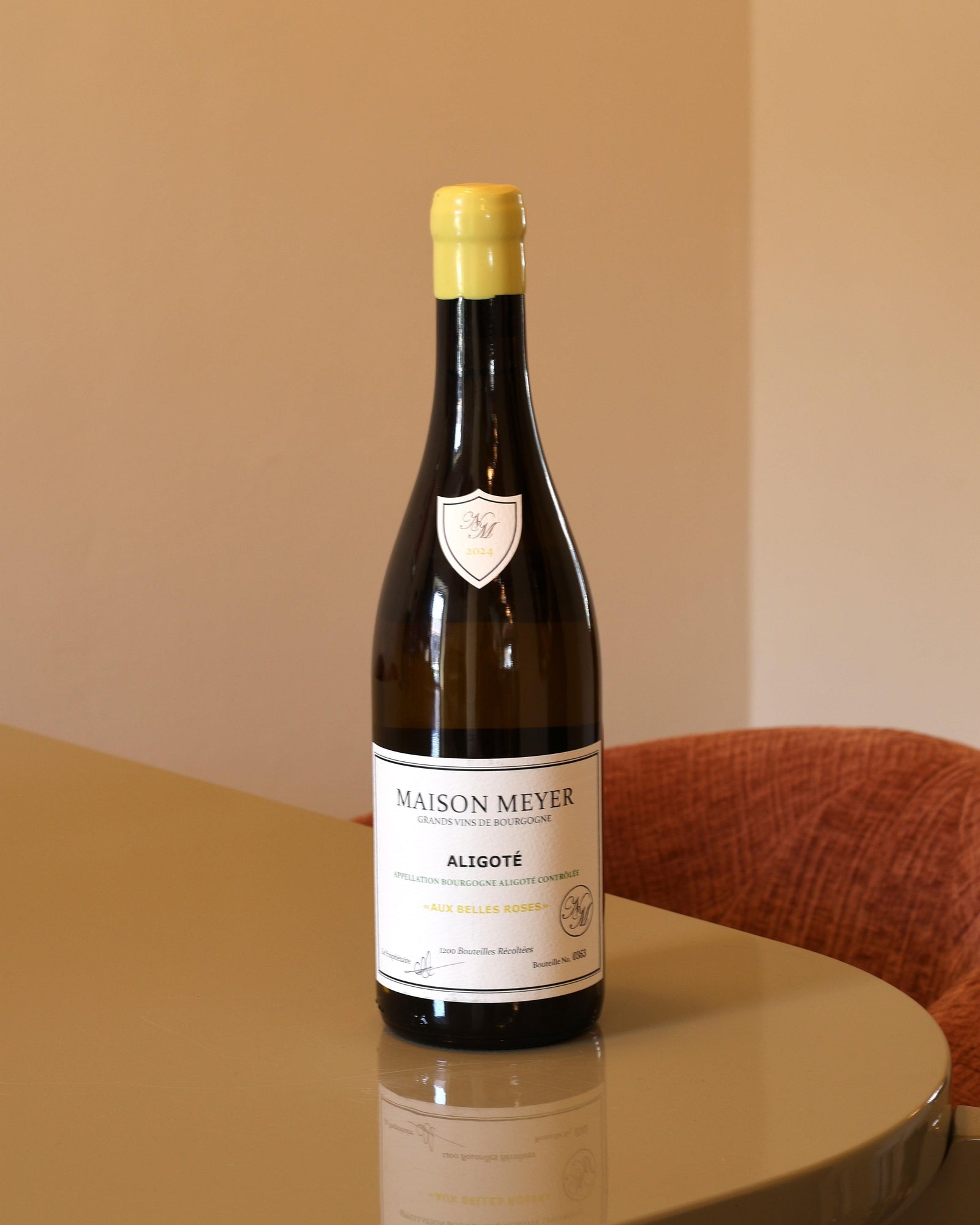 Bottiglia di vino bianco Maison Meyer Bourgogne Aligote 2024 con etichetta bianca e capsula gialla su tavolo lucido.