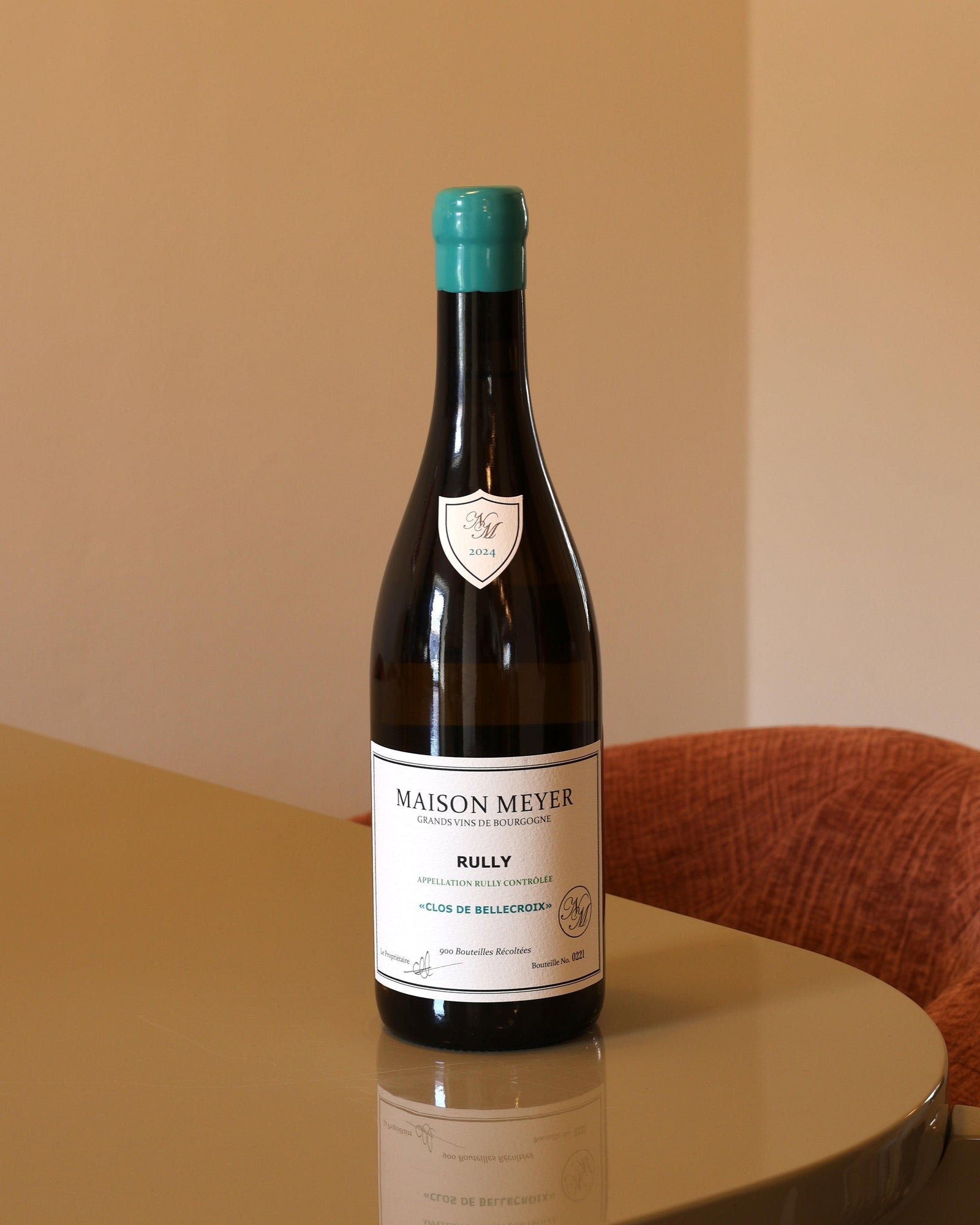 Bottiglia di vino bianco Maison Meyer Rully Blanc 2024 con capsula verde acqua su tavolo lucido.