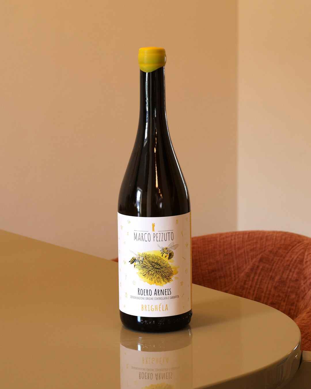 Bottiglia di vino bianco Marco Pezzuto Arneis Brighela 2024 da 0,75l con etichetta illustrata su tavolo lucido.