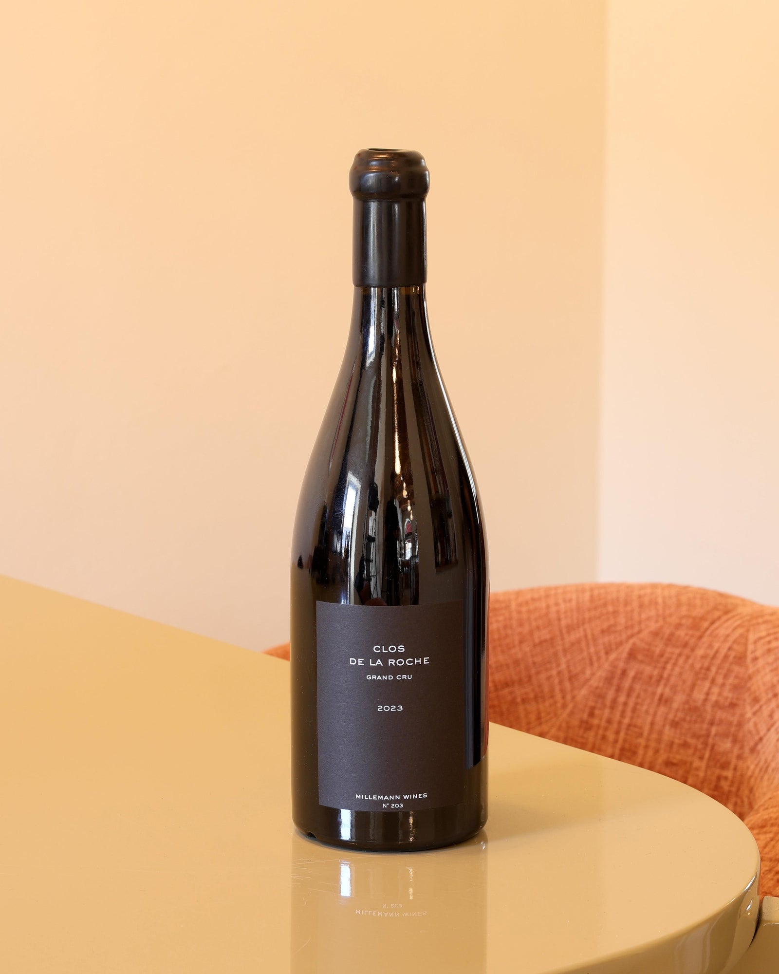 Bottiglia di vino rosso Millemann Clos de la Roche 2023, 0,75l, con etichetta nera minimalista su tavolo lucido.