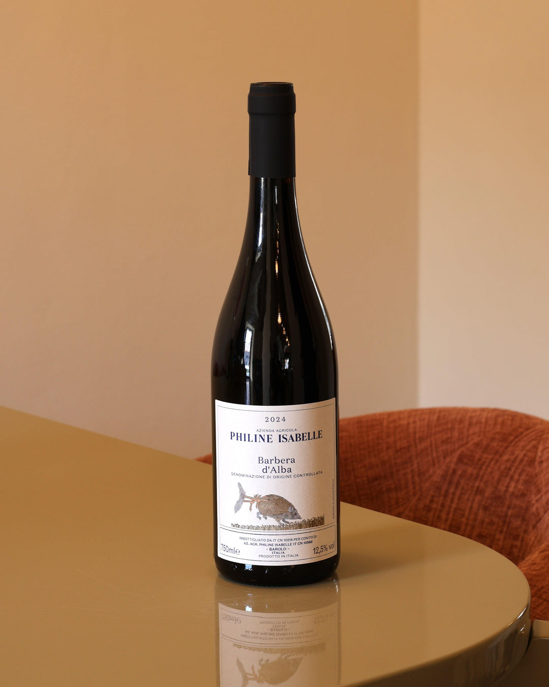 Bottiglia di vino Philine Isabelle Barbera d'Alba 2024 da 0,75l con etichetta bianca illustrata su tavolo lucido.