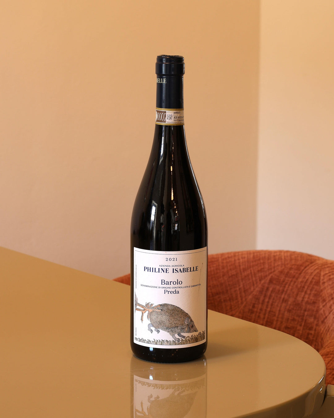 Bottiglia di vino rosso Philine Isabelle Barolo Preda 2021 da 0,75l con etichetta illustrata su tavolo lucido.