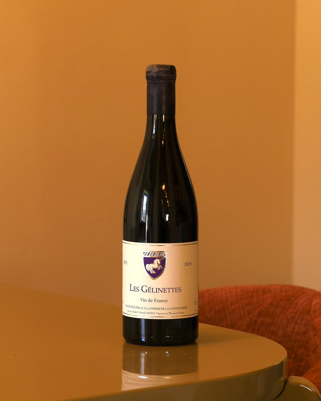 Bottiglia di vino Sansonniere Les Gelinettes 2021 da 0,75l con etichetta bianca e stemma su sfondo color ocra.