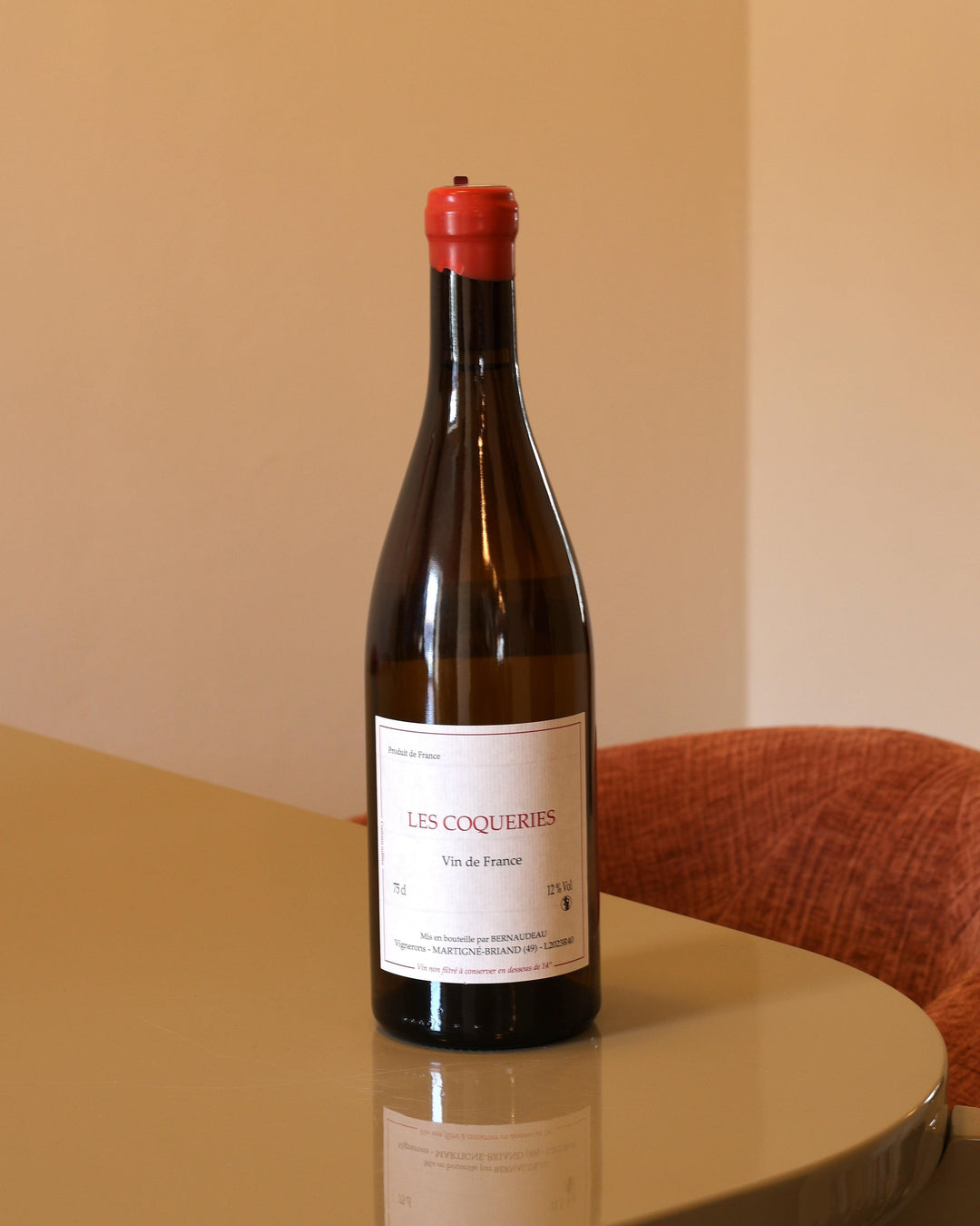 Bottiglia di vino Stephane Bernadeau Les Coqueries 2023 da 0,75l con etichetta bianca e capsula rossa su tavolo lucido.