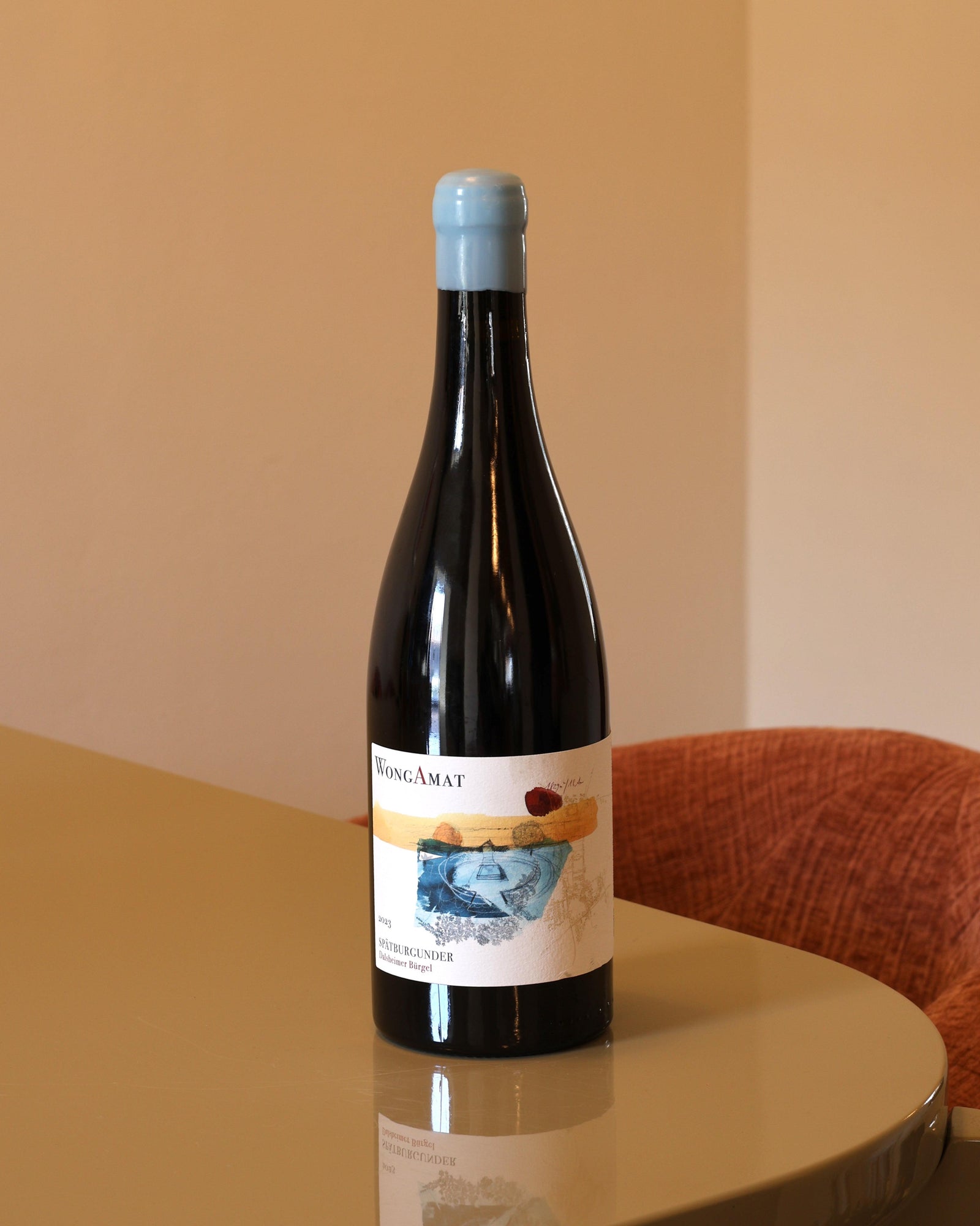 Bottiglia di vino rosso Wong Amat Burgel 2023 da 0,75l con etichetta artistica su tavolo moderno.