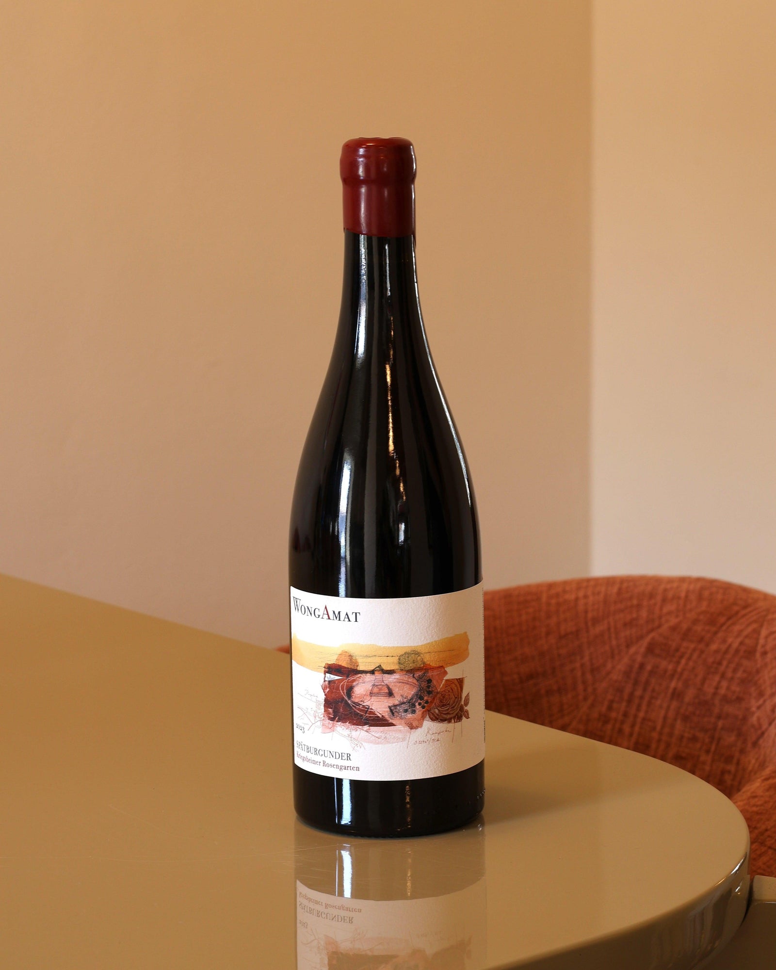 Bottiglia di vino rosso Wong Amat Rosengarten 2023 da 0,75l con tappo in ceralacca rossa su tavolo lucido.